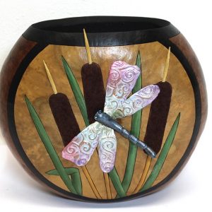 A decorative gourd container with a draonfly and some cattails