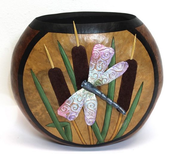 A decorative gourd container with a draonfly and some cattails