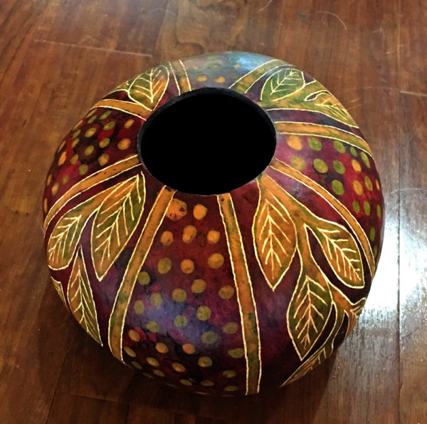 A gourd painted in multiple colors and patterns