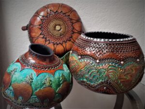 Three carved gourds sit on a display together
