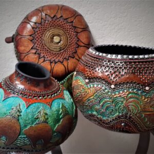 Three carved gourds sit on a display together