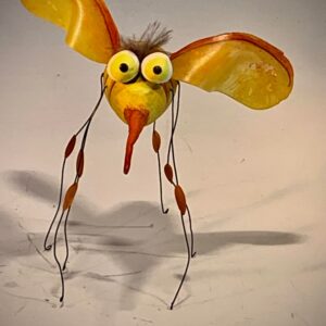 A carved gourd resembling a mosquito sits displayed on a table